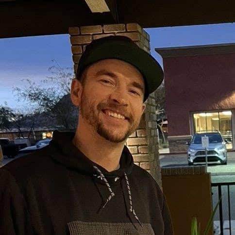 Brandon, Flagstaff Après Ski team member, smiling in a black cap