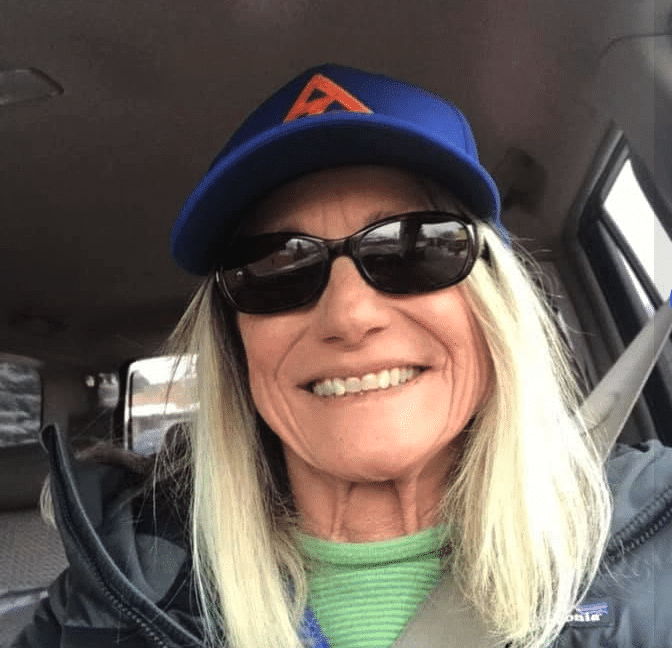 Linda, Flagstaff Après Ski team member, smiling in a blue cap and sunglasses